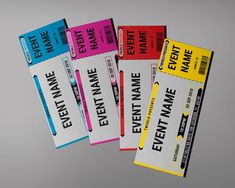 four tickets with different colored labels on them are flying through the air in front of a gray background