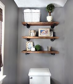 a bathroom with two shelves above the toilet