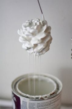 a paint can being filled with white whipped cream