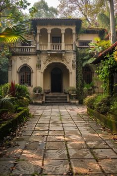 the entrance to an old style house surrounded by greenery