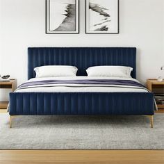 a blue bed with two pictures above it