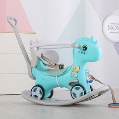 a blue toy horse pulling a baby's carriage with a teddy bear on it