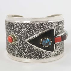 Tufa Cast Sterling Silver Cuff Bracelet with a Natural Bisbee Turquoise Stone in a 14K Gold Bezel set on a Cobbled Inlay Arrow Design using Ebony, Coral and Natural Bisbee Turquoise. This bracelet also features a coral stone set in 14k gold bezel. 1.75” Cuff Width5.375” Inside Measurement, plus .875” opening(6.25" Total Circumference - Small-Medium) Distinctive Bangle With Inlay For Gifts, Unique Inlay Bangle Gift, Unique Bangle With Inlay As Gift, Unique Bangle With Inlay For Gift, Adjustable Multi-stone Cuff Bracelet Gift, Unique Multi-stone Bangle Bracelets, Unique Multi-stone Bangle Bracelet, Unique Adjustable Multi-stone Cuff Bracelet, Elegant Inlay Cuff Bracelet Bangle