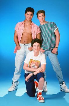 three young men posing for a photo in front of a blue background