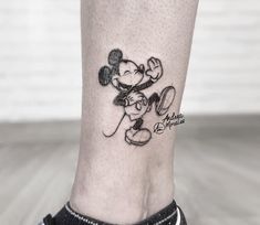 a small mickey mouse tattoo on the ankle