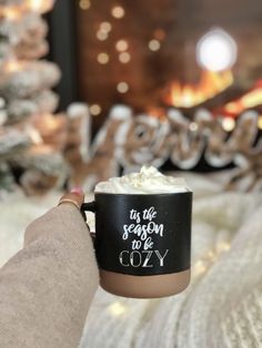 someone is holding a coffee cup with whipped cream on it and the words, its the season to be cozy