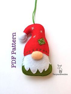 a felt christmas ornament with a red santa hat and green trimmings