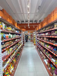 an aisle in a grocery store filled with lots of shelves and food on the shelves