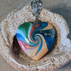 Beautiful Swirl Necklace In Shades Of Blues, Greens, Pinks And Peaches. Accompanied By A 18" Silver Chain, This One-Of-A-Kind Necklace Will Make A Fantastic Statement Piece To Any Outfit! Pendant Measures Approximately 1.25"H X 1.25"W. From A Non-Smoking Home. Cc7 Multicolor Spiral Necklace Gift, Spiral Multicolor Necklace Gift, Blue Spiral Necklace For Gift, Unique Blue Jewelry With Heart Charm, Unique Blue Heart Pendant Necklace, Unique Blue Heart-shaped Necklace, Unique Blue Jewelry For Valentine's Day, Swirl Necklace, Peaches