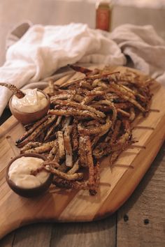 a wooden cutting board topped with fried food