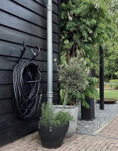 two large black planters sitting next to each other on the side of a building