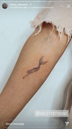 a woman's arm with a small bird tattoo on the left side of her arm