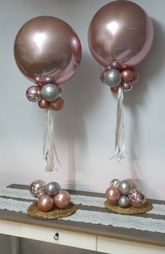 two pink and silver balloons sitting on top of a table