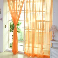 an open window with sheer curtains in the living room