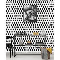 a black and white polka dot wallpaper with a flower on the left hand side