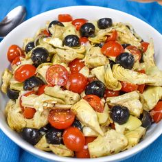 a white bowl filled with lots of different types of food on top of a blue cloth