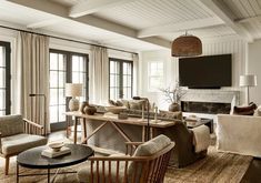 a living room filled with furniture and a flat screen tv mounted on the wall above a fireplace