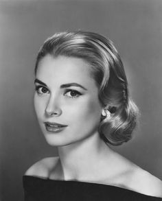 an old black and white photo of a woman in a dress with her hair up