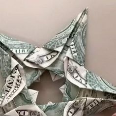 someone is holding up a folded dollar bill origami star