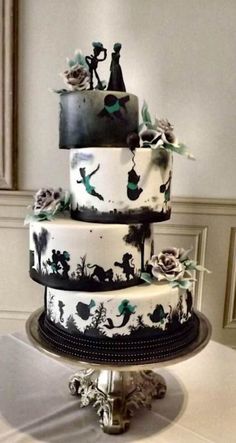 a three tiered cake decorated with black and white designs