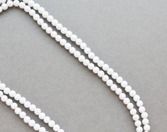 "-long lightweight plastic bead necklace -44\" long necklace -can be used long as shown or wrapped around. -each bead is about 5/16\" wide" White Single Strand Long Beaded Necklace, White Long Chain Necklace, White Beaded Long Necklace With Round Beads, White Beaded Chain Long Necklace, White Long Beaded Necklace With Round Beads, White Single Strand Necklace With Round Beads, White Beaded Long Necklace, White Long Necklace With Round Beaded Details, White Long Necklace With Round Beads