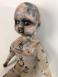 an old doll with writing all over it's body