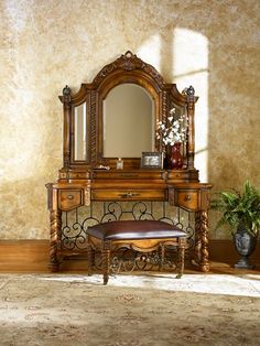 an ornate wooden dressing table with mirror and stool