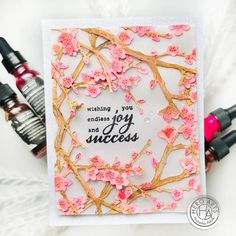 a card with pink flowers on it and two bottles of ink next to the card