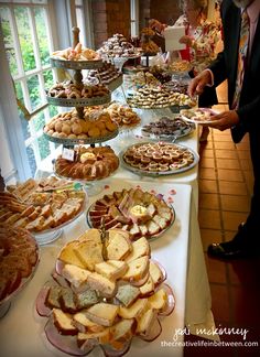 a man standing in front of a buffet table filled with pastries and desserts