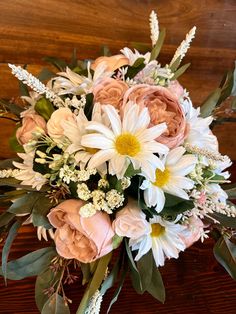 a bouquet of flowers sitting on top of a wooden table