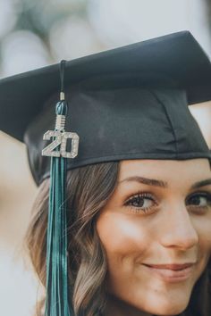 a woman wearing a graduation cap and gown with the number 20 on it's tassel