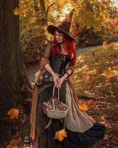 a woman dressed as a witch sitting under a tree with a basket in her hand