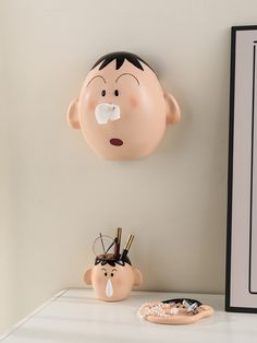 there is a plastic head on the wall next to a clock and other items in front of it