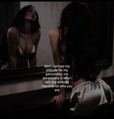 a woman looking at herself in the mirror with her hand on her hip and another person's reflection behind her