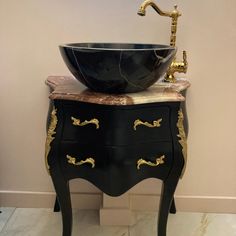 a black sink sitting on top of a wooden cabinet