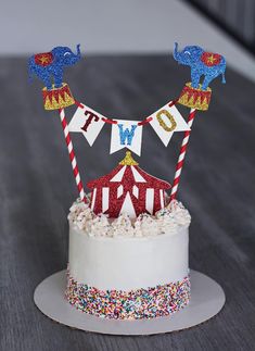 a circus themed birthday cake on a table with confetti sprinkles