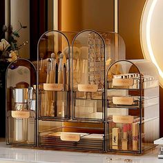 an assortment of cosmetics and makeup products on display in front of a mirror with flowers