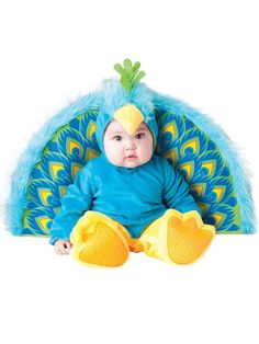 a baby in a blue bird costume sitting on the ground