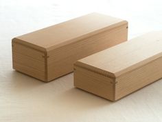 two wooden boxes sitting side by side on a white surface