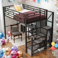 a loft bed with a desk underneath it and balloons all around the room on the floor