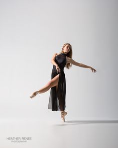 a woman in a black dress is dancing with her legs spread out and one leg bent