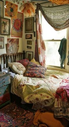 a bed sitting in a bedroom next to a window with pictures on the wall above it