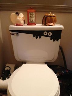 a white toilet with halloween decorations on the lid