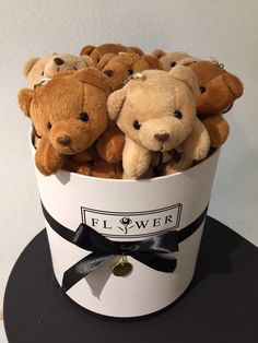 a bunch of brown teddy bears in a white bucket