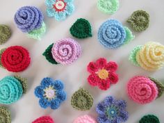 crocheted flowers are arranged on a white surface