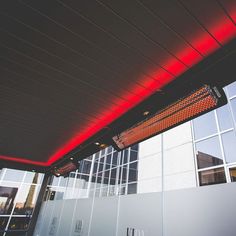 a red light shines on the side of a building's roof and walls