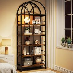 a room with a bed, lamp and bookcase in the corner on the floor