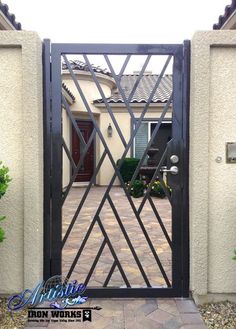 an iron gate in front of a house with a brick walkway leading to the entrance