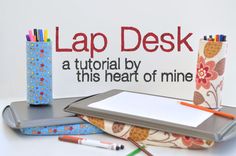 a laptop computer sitting on top of a desk next to pencils and paper rolls