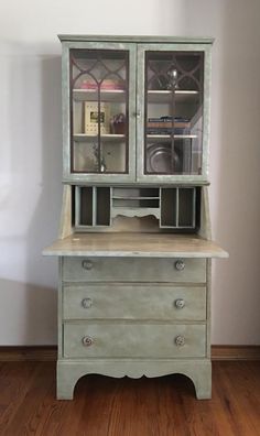 an old china cabinet with glass doors and drawers